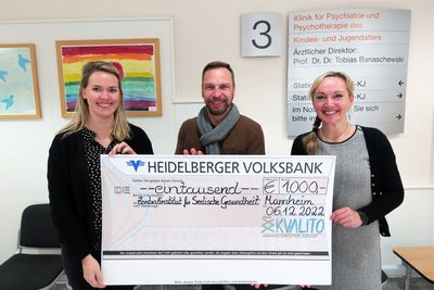 Julia Jornitz und Barbara Stroh von KVALITO halten einen großen Scheck zusammen mit ZI-Mitarbeiter Rolf Oster-Ritter in der Hand. Damit Unterstützen sie Kinder und Jugendliche in Behandlung.