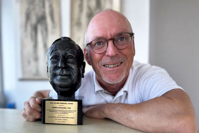 Prof. Dr. Rainer Spanagel ist neben der Büste des Jellinek-Forschungspreises zu sehen. 