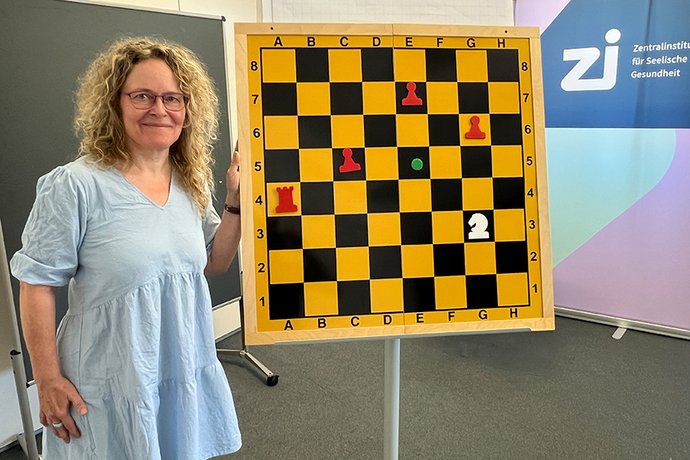 Prof. Dr. Sabine Vollstädt-Klein steht neben einem großen Schachbrett.