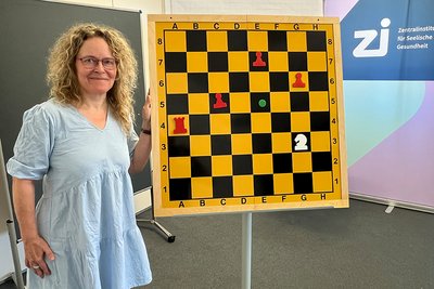 Prof. Dr. Sabine Vollstädt-Klein steht neben einem großen Schachbrett.