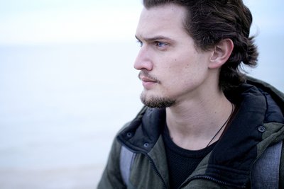 A pensive young man by the sea.