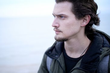 Ein nachdenklicher junger Mann am Meer.