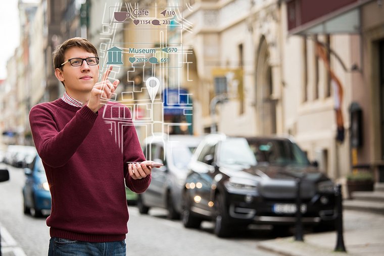 Ein junger benutzt eine AR-Anwendung, um durch eine Stadt zu navigieren. 