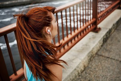Körperliche Aktivität kann Folgen von Kindheitstrauma abmildern Eine junge Frau joggt über eine Brücke.
