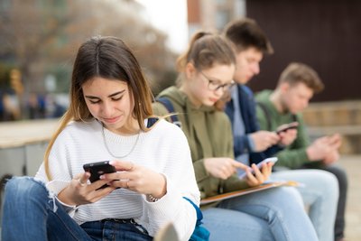 Eine Gruppe Jugendlicher mit ihren Smartphones.