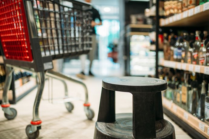 Ein Einkaufswagen steht im Supermarkt vor dem Alkoholregal. Der Abstatz von Alkohol ist während des Shutdowns gestiegen.