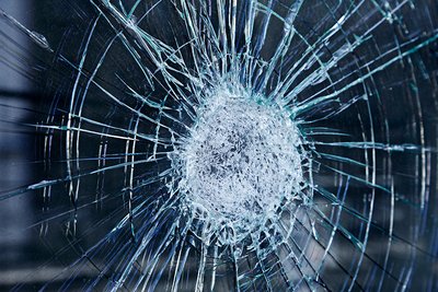 Eine Glasscheibe ist durch Aggression beschädigt worden und weist sehr viele Risse auf.