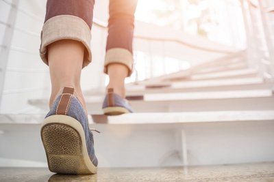 Eine junge Frau steigt eine Treppe in einem Haus hinauf. 