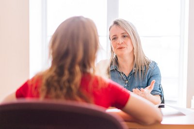 Two women are sitting opposite each other in a conversation.