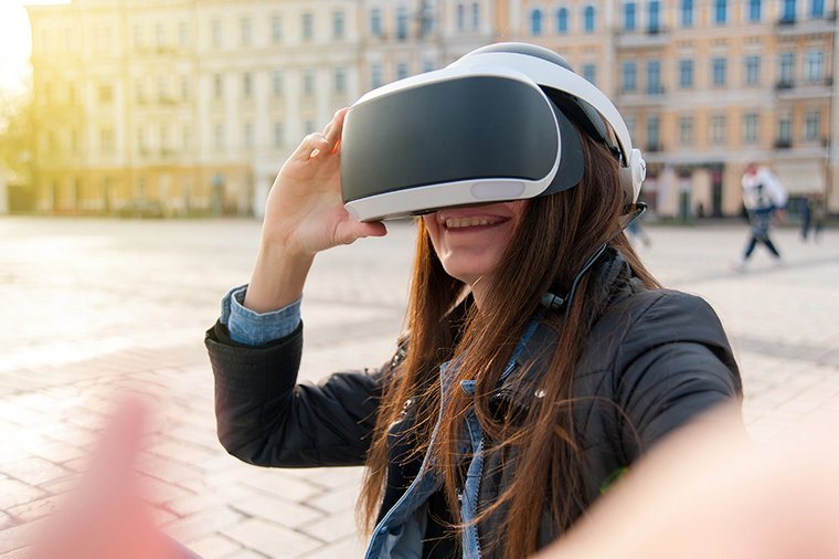 Eine junge Frau befindet sich auf einem Marktplatz und trägt eine VR-Brille.